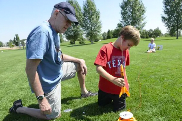 Young boy building model rocket.